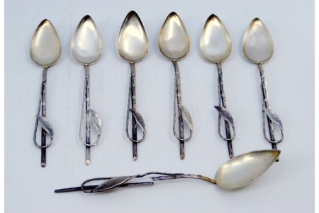 Conjunto de seis colheres de café e pá de açúcar em prata com relevos e aplicação de folhas nos cabos.